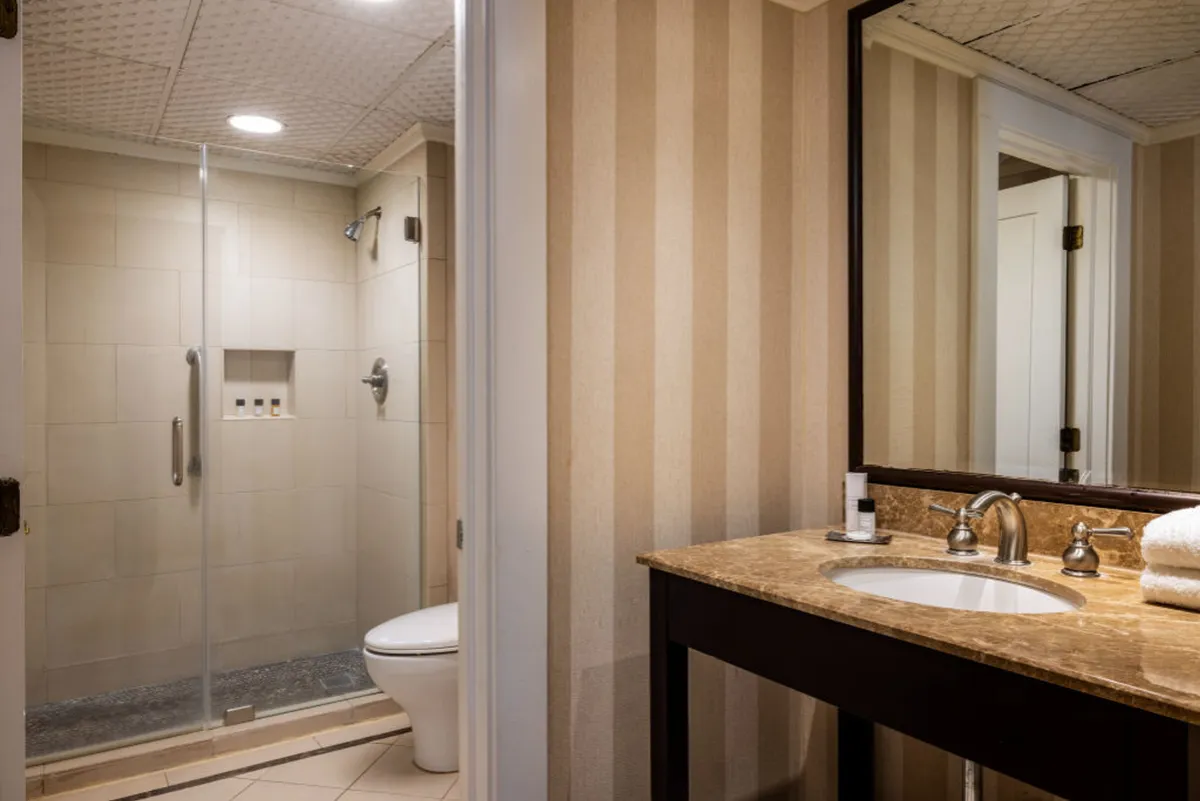 This interior image captures a contemporary bathroom with a spacious walk-in shower, a sleek vanity with sink, and a large mirror. The neutral color palette and clean lines create an inviting and tranquil atmosphere, perfectly suited to spa-like routines.